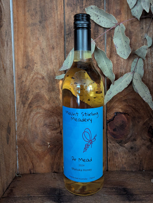 Bottle of mead with a blue label on a wooden background